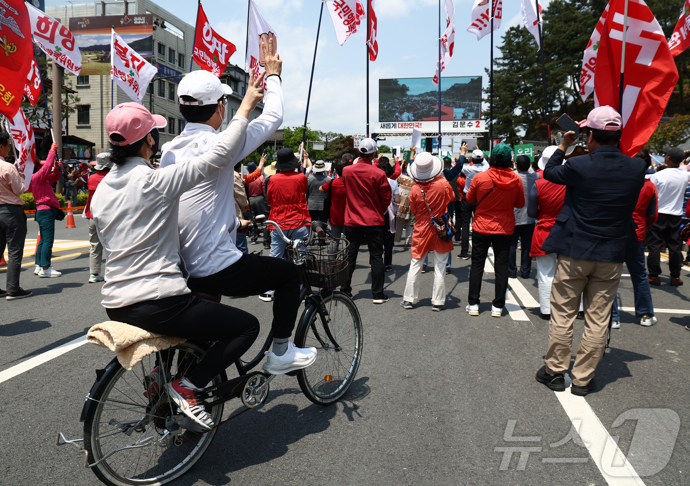 (공주=뉴스1) 김민지 기자 = 김문수 국민의힘 대통령 후보가 25일 오후 세계문화유산인 충남 공주시 공산성 인근에서 유세를 하고 있는 가운데 자전거를 탄 시민들이 기호2번을 외치 …