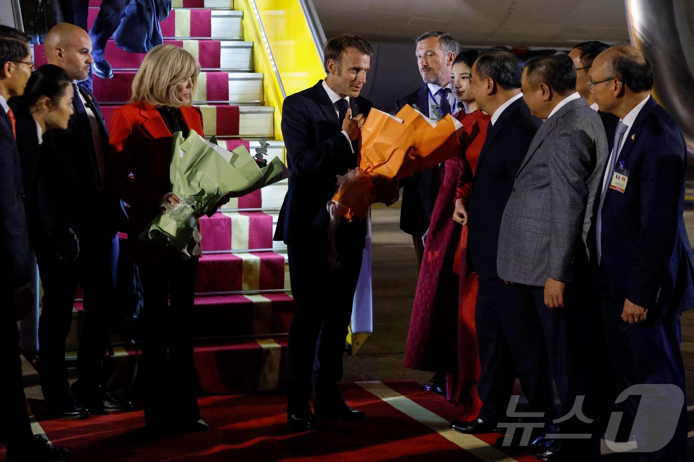 (베트남 하노이 AFP=뉴스1) 신기림 기자 = 에마뉘엘 마크롱 프랑스 대통령(가운데)과 부인 브리지트 마크롱이 5월 25일 하노이 노이바이 국제공항에 도착해 베트남 관리들의 환영 …