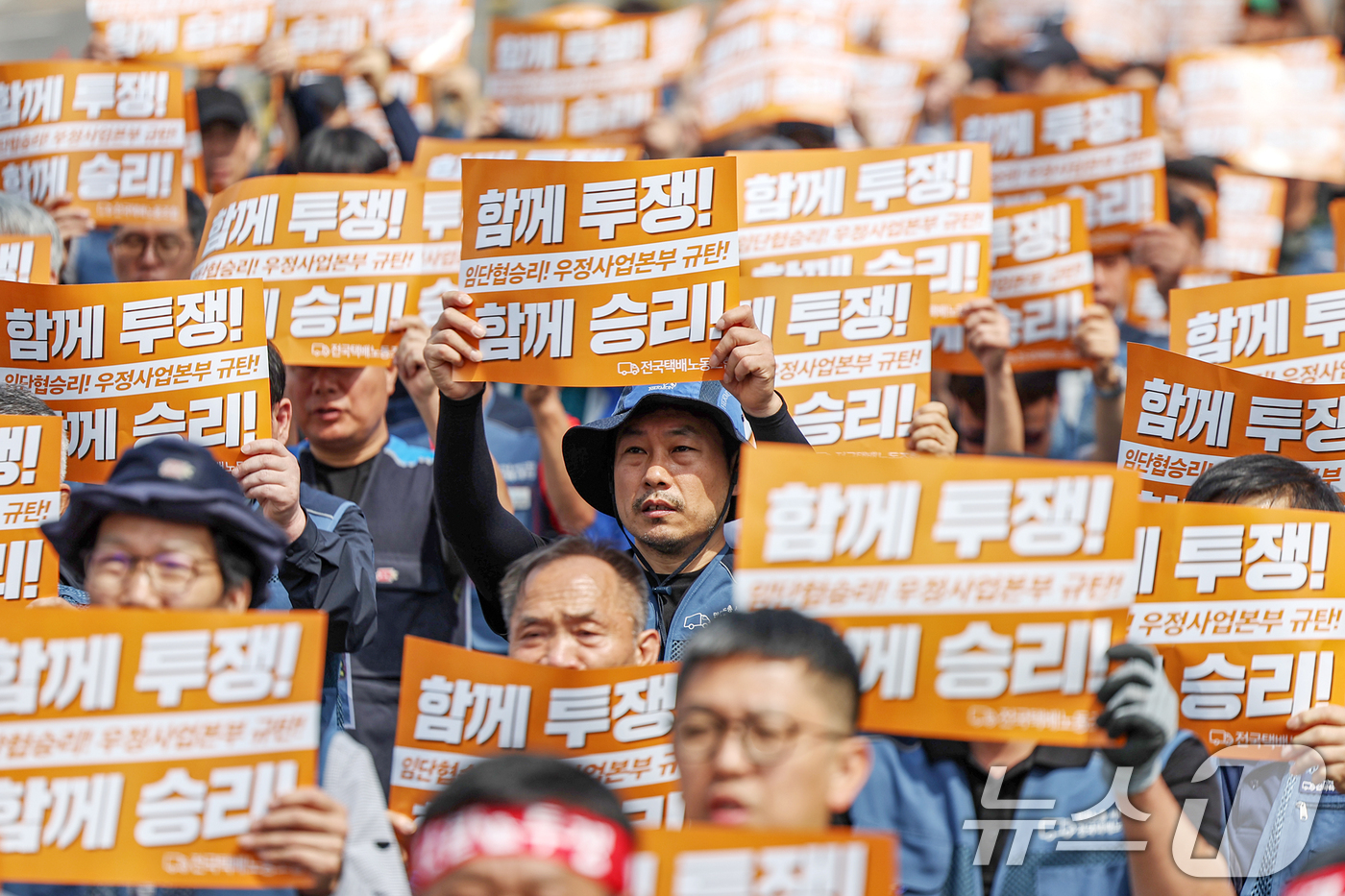 (서울=뉴스1) 민경석 기자 = 전국택배노조 우체국본부 조합원들이 26일 오전 서울 광진구 동서울우편집중국 앞에서 열린 '6월 총력투쟁 선포 결의대회'에서 구호를 외치고 있다.조합 …