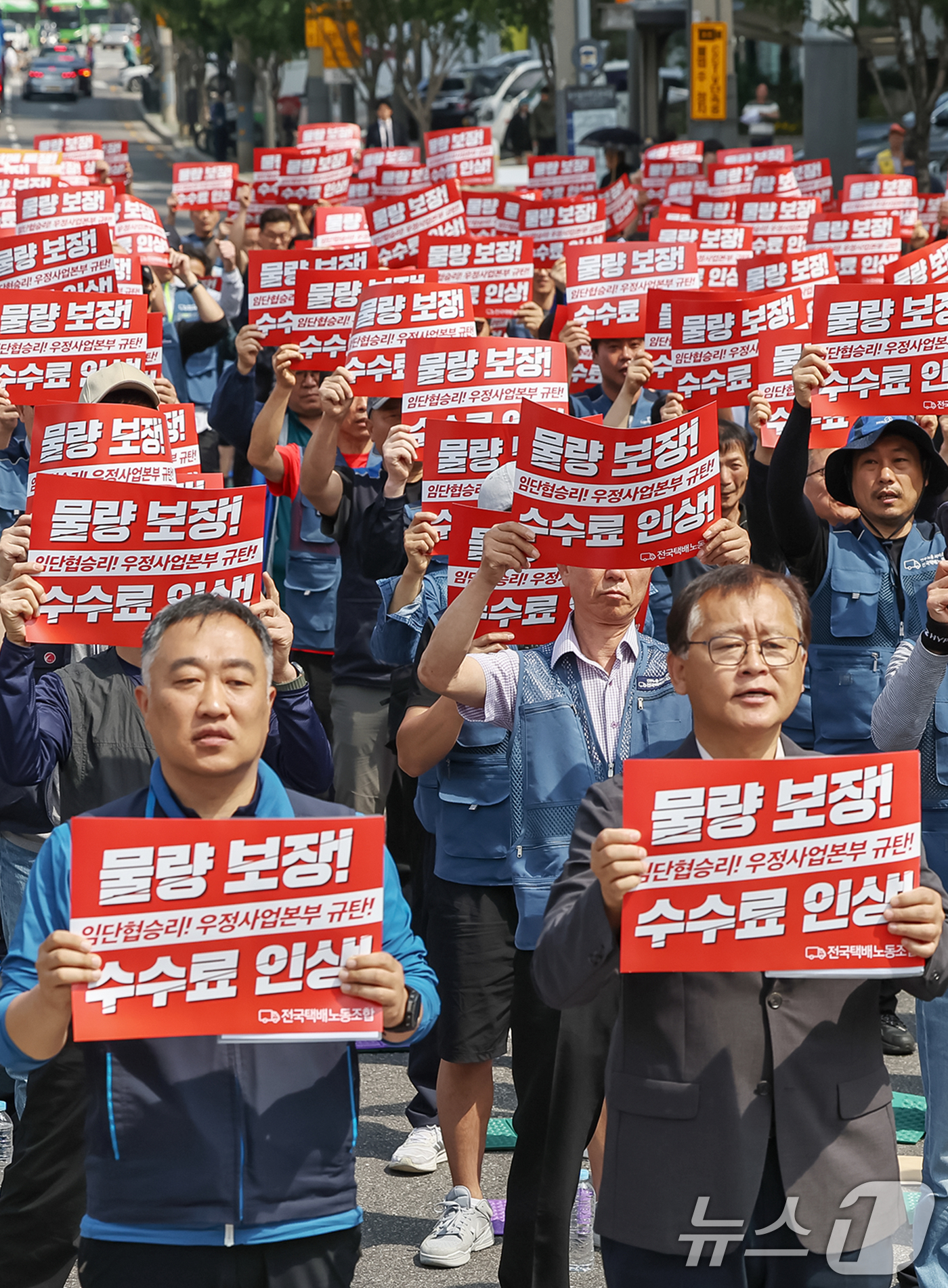 (서울=뉴스1) 민경석 기자 = 전국택배노조 우체국본부 조합원들이 26일 오전 서울 광진구 동서울우편집중국 앞에서 열린 '6월 총력투쟁 선포 결의대회'에서 구호를 외치고 있다.조합 …