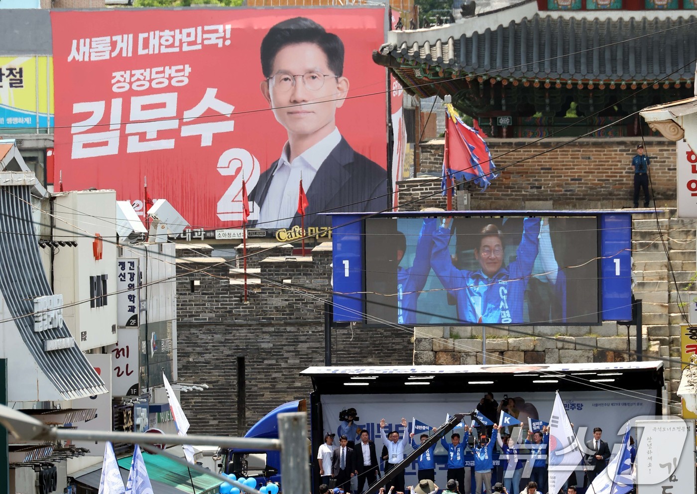 (수원=뉴스1) 안은나 기자 = 이재명 더불어민주당 대통령 후보가 26일 오후 경기 수원시 팔달문 영동시장 입구를 찾아 집중 유세를 펼치는 가운데 무대 인근에 김문수 국민의힘 후보 …