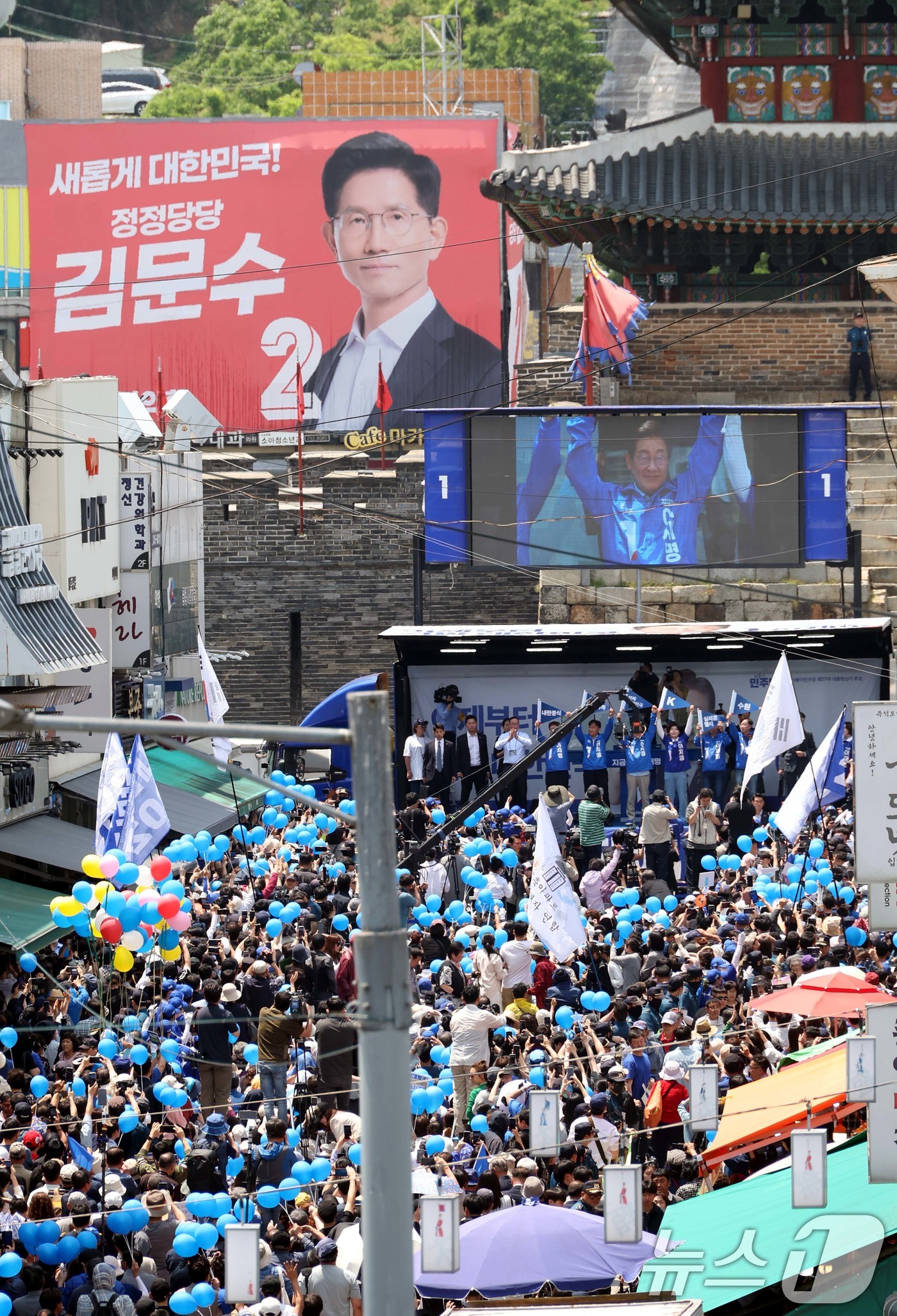 (수원=뉴스1) 안은나 기자 = 이재명 더불어민주당 대통령 후보가 26일 오후 경기 수원시 팔달문 영동시장 입구를 찾아 집중 유세를 펼치는 가운데 무대 인근에 김문수 국민의힘 후보 …