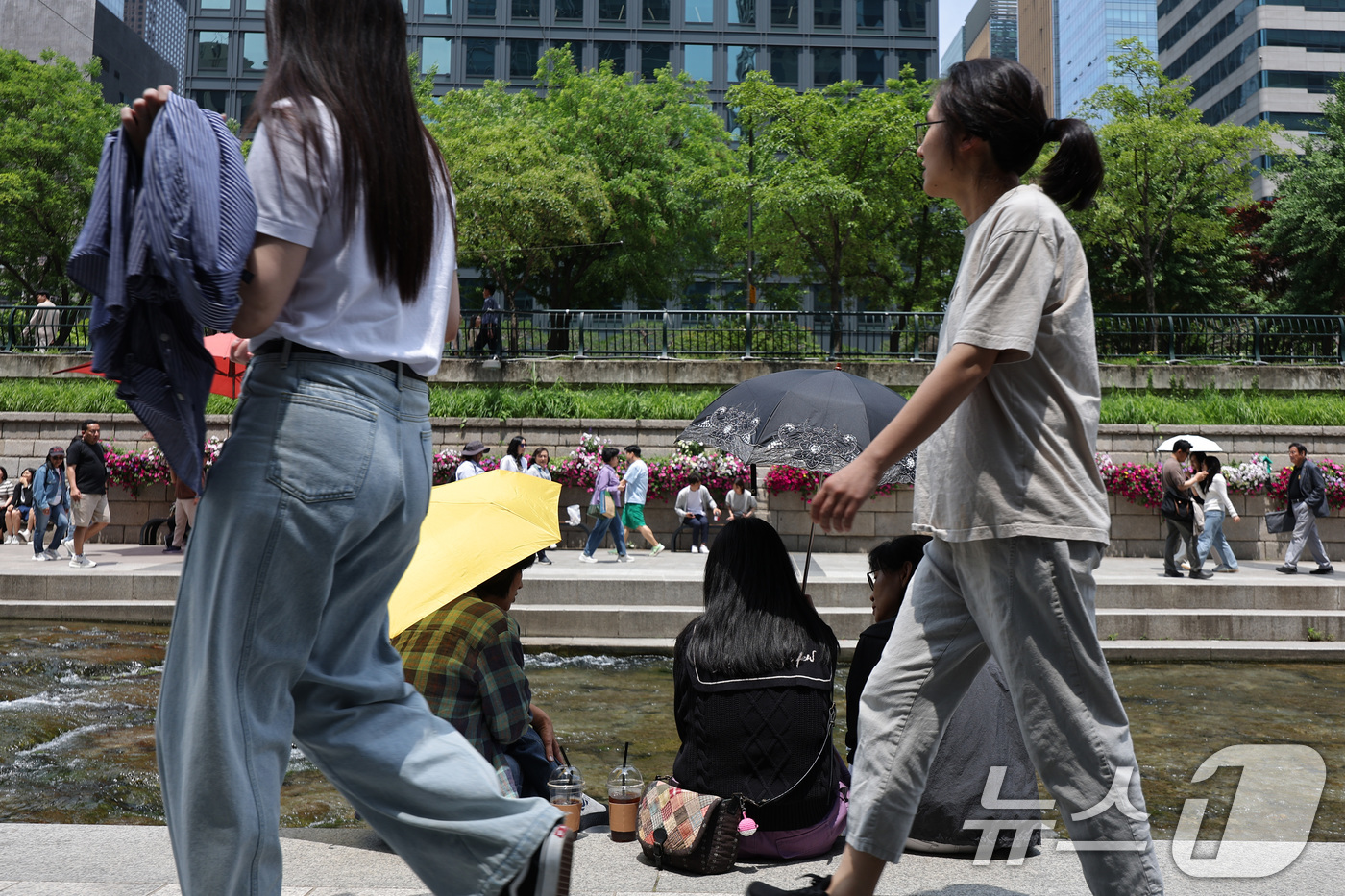 (서울=뉴스1) 신웅수 기자 = 26일 오후 서울 청계광장에서 겉옷을 벗거나 양산을 쓴 시민들이 올해 마지막 봄을 즐기고 있다.기상청은 내일과 모레 동쪽 지방을 중심으로 요란한 소 …