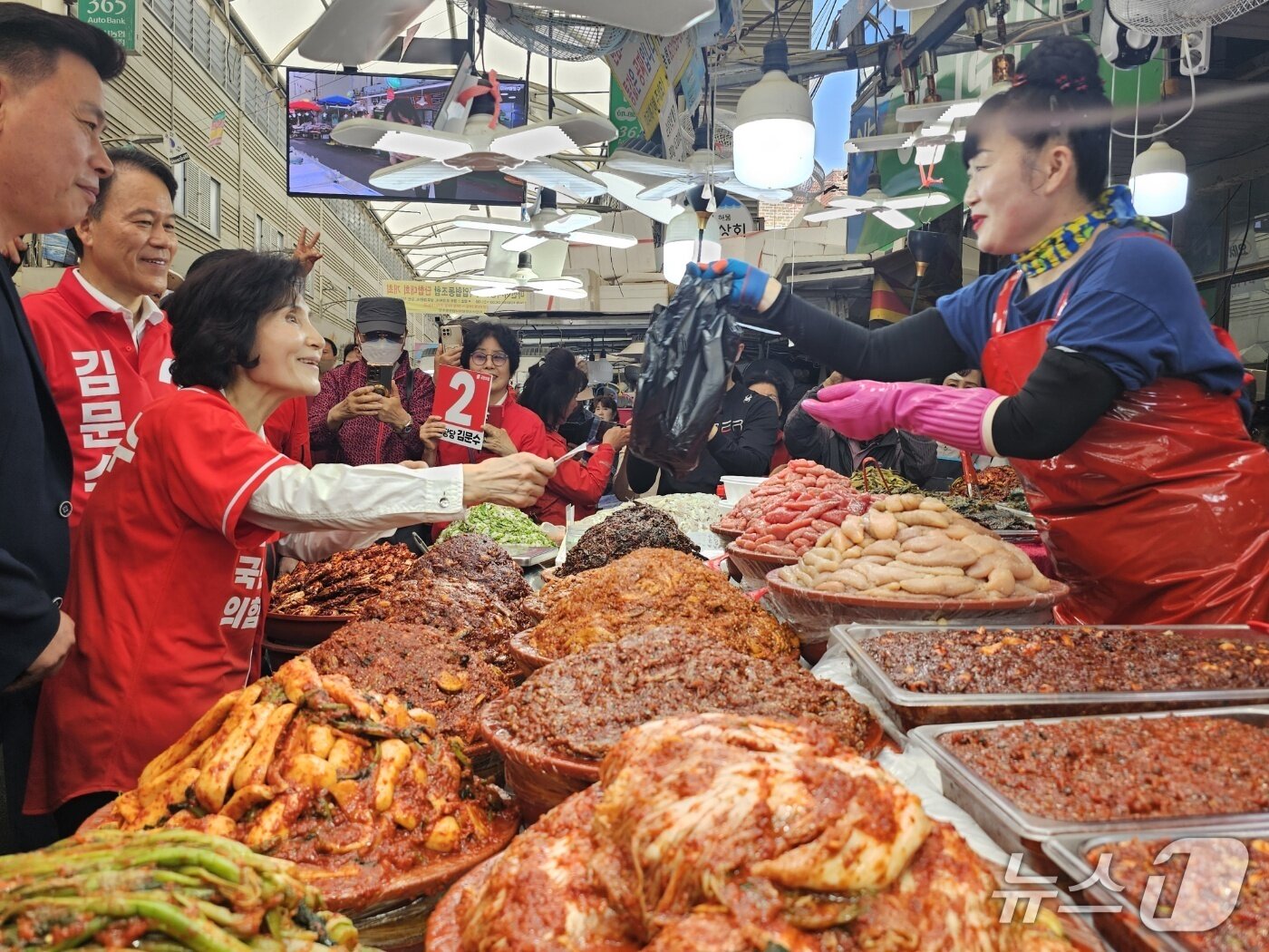 본문 이미지 - 김문수 국민의힘 대통령 후보의 배우자인 설난영 여사가 26일 마산어시장을 찾아 한 상인에게 젓갈을 구매하고 있다. ⓒ 뉴스1 박민석 기자