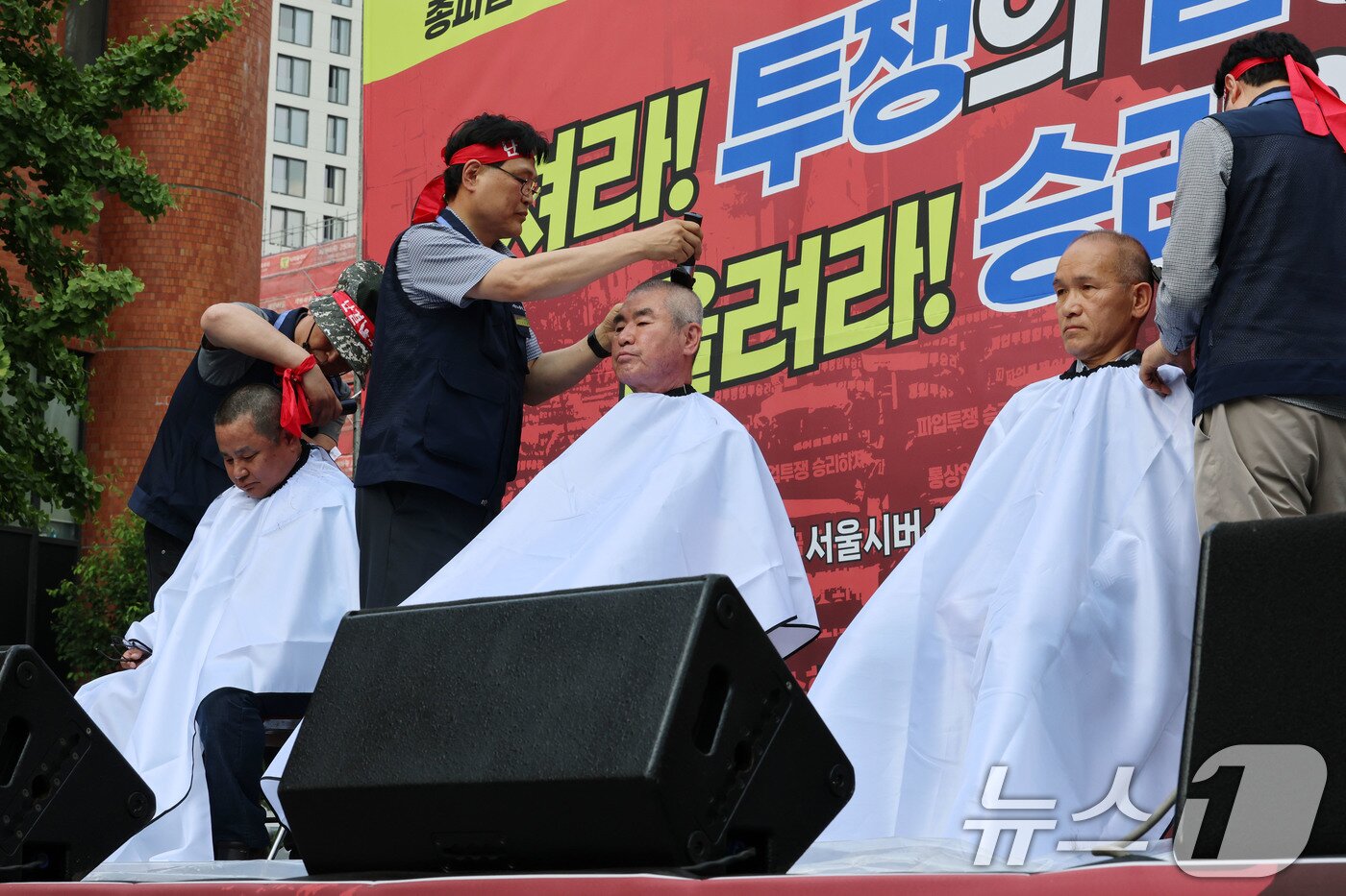 본문 이미지 - 26일 서울 송파구 교통회관 앞에서 열린 서울시버스노조 총파업 투쟁 승리쟁취 버스노동자 결의대회에서 교섭위원들이 삭발식을 하고 있다.  /뉴스1