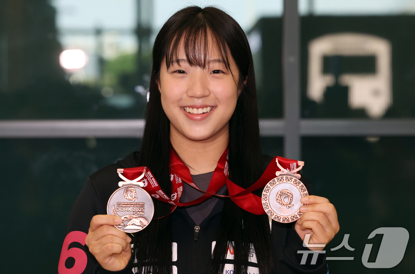 (인천공항=뉴스1) 김명섭 기자 = 탁구 국가대표 신유빈이 26일 인천공항에서 2025 카타르 도하 세계탁구선수권대회를 마치고 귀국해 메달을 들어보이고 있다. 신유빈은 이번 대회 …