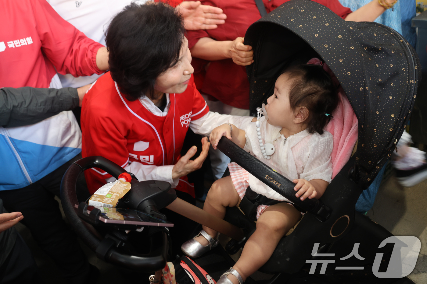 (서울=뉴스1) = 김문수 국민의힘 대통령 후보 부인 설난영 여사가 26일 울산 태화시장을 찾아 아이와 눈을 맞추고 있다. (국민의힘 제공) 2025.5.26/뉴스1