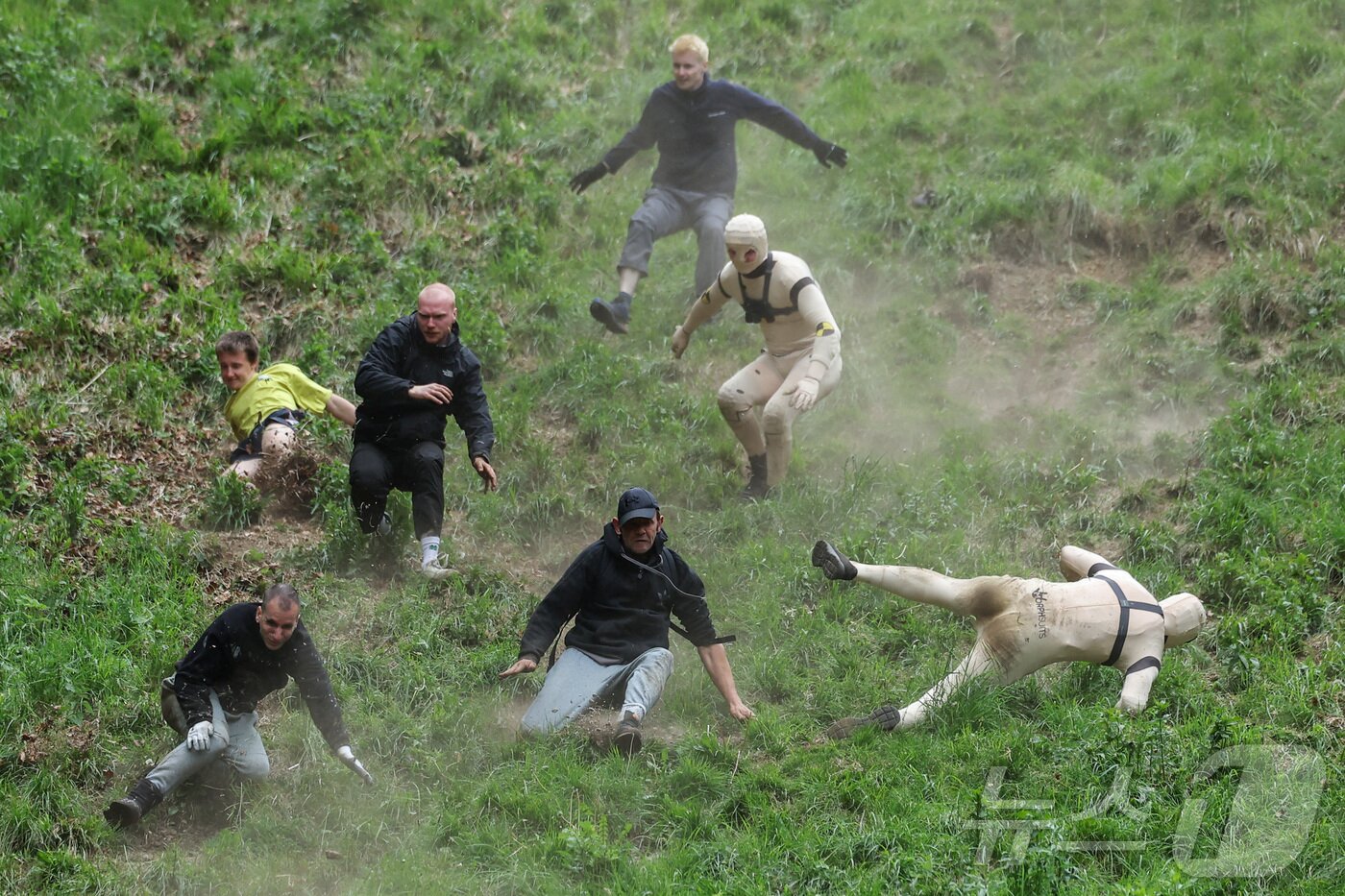 본문 이미지 - 26일(현지시간) 영국 브록웍스의 쿠퍼스 힐에서 열린 '구르는 치즈 잡기' 대회에서 참가자들이 치즈를 쫒아 언덕을 내려가다 넘어지고 있다. ⓒ 로이터=뉴스1