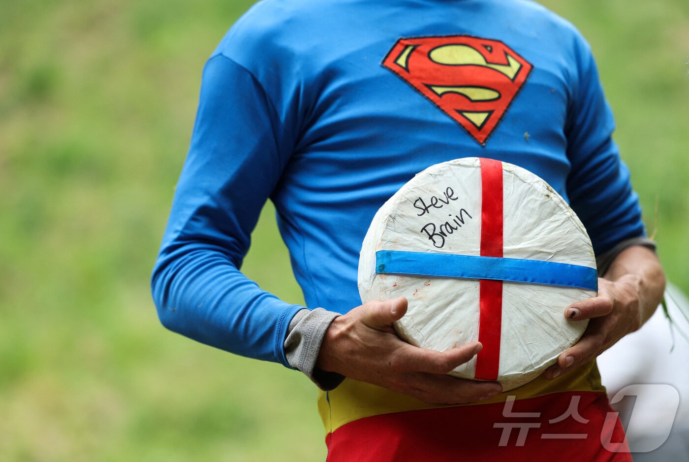 본문 이미지 - 26일(현지시간) 영국 브록웍스의 쿠퍼스 힐에서 열린 '구르는 치즈 잡기' 대회에서 두 번째 경기 우승자가 치즈 바퀴를 들고 기뻐하고 있다.ⓒ 로이터=뉴스1