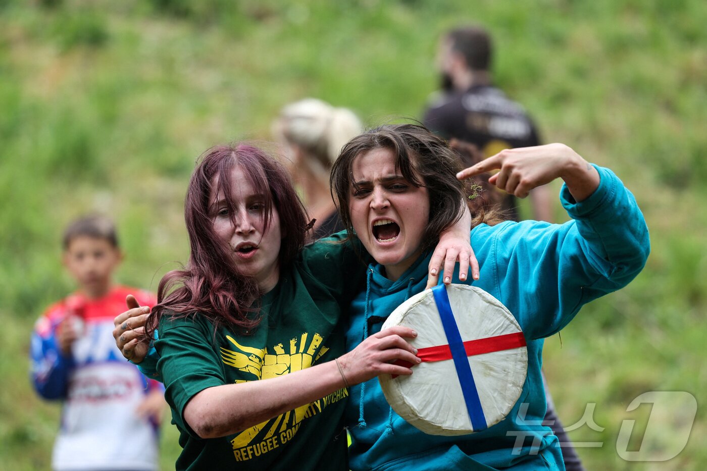 본문 이미지 - 26일(현지시간) 영국 브록웍스의 쿠퍼스 힐에서 열린 '구르는 치즈 잡기' 대회에서 참가자들이 치즈 바퀴를 들고 포즈를 취하고 있다. ⓒ 로이터=뉴스1