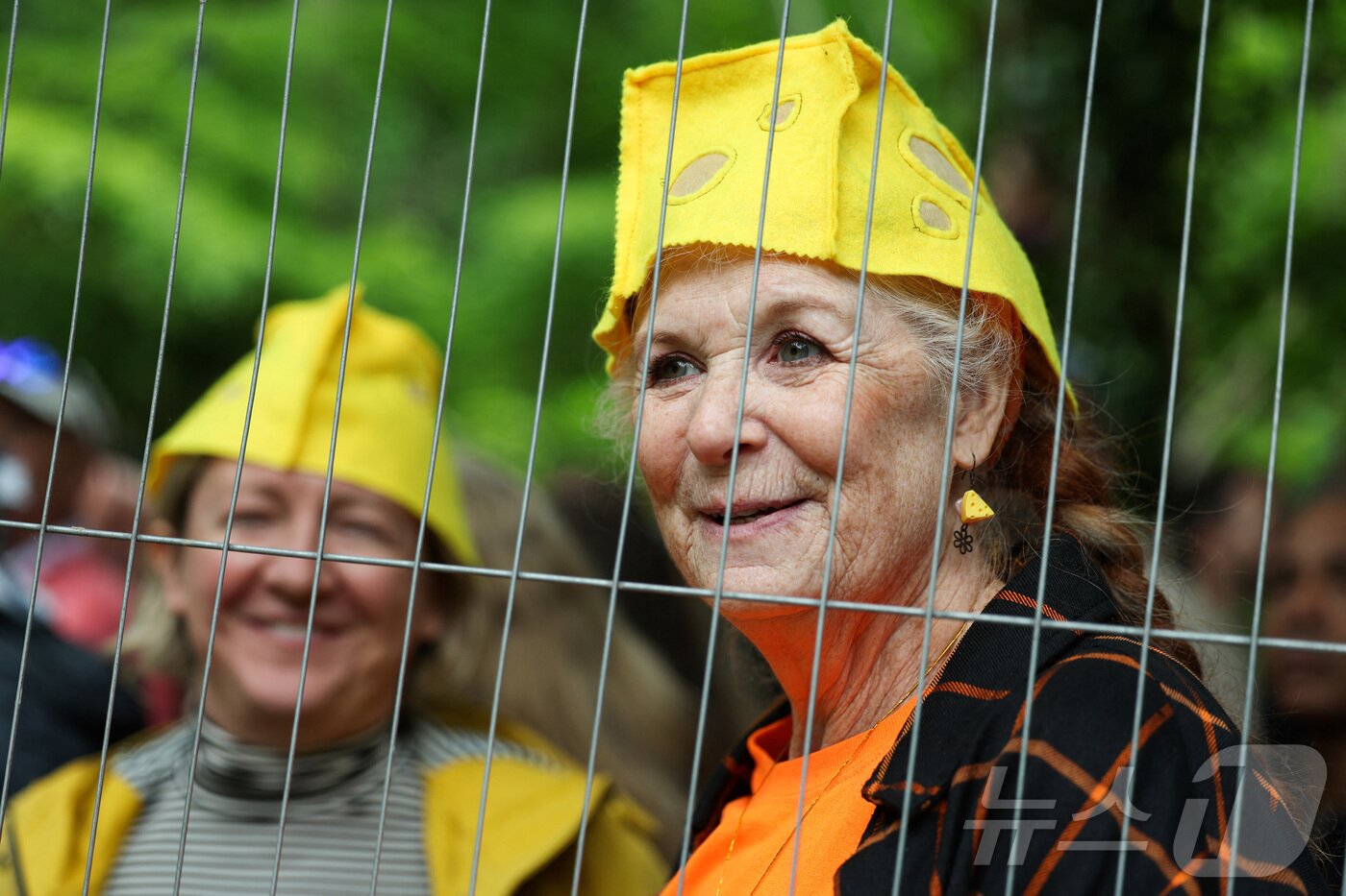 본문 이미지 - 26일(현지시간) 영국 브록웍스의 쿠퍼스 힐에서 열린 '구르는 치즈 잡기' 대회에서 관람객들이 치즈 모자를 쓰고 있다. ⓒ 로이터=뉴스1