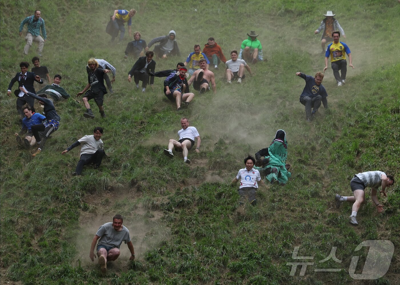 본문 이미지 - 26일(현지시간) 영국 브록웍스의 쿠퍼스 힐에서 열린 '구르는 치즈 잡기' 대회에서 참가자들이 치즈를 쫒아 언덕을 내려가고 있다. ⓒ 로이터=뉴스1