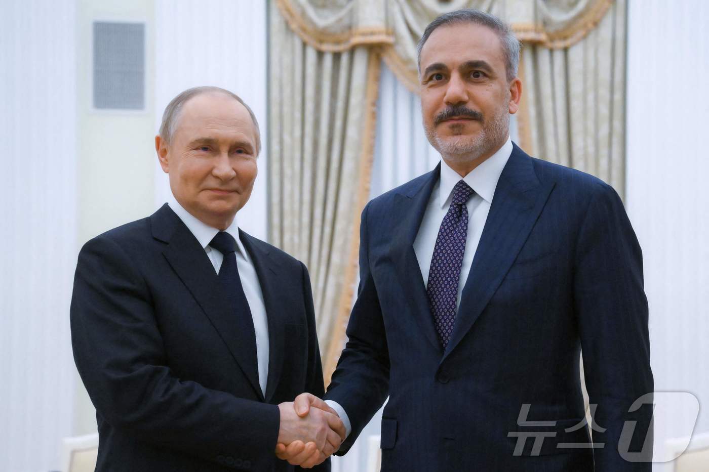 (모스크바 AFP=뉴스1) 우동명 기자 = 블라디미르 푸틴 러시아 대통령이 26일(현지시간) 모스크바 크렘렌 궁에서 하칸 피단 튀르키예 외무장관과 만나 악수를 하고 있다. 2025 …