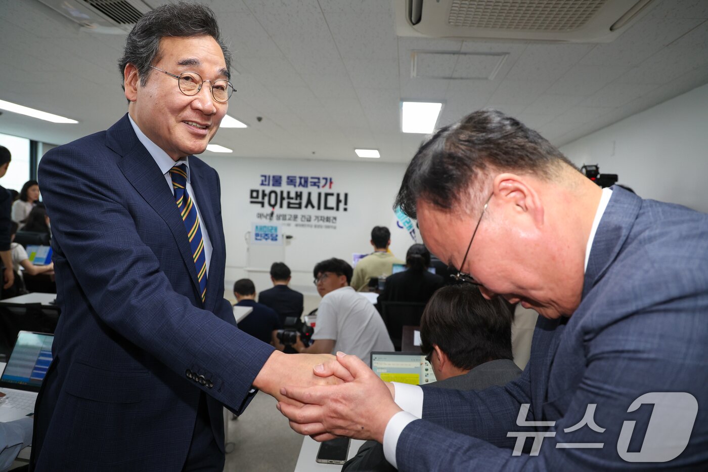 본문 이미지 - 이낙연 새미래민주당 상임고문이 27일 서울 여의도 당사에서 기자회견을 마친 뒤 김문수 국민의힘 대통령 후보측 김재원 비서실장과 악수하고 있다. 2025.5.27/뉴스1 ⓒ News1 안은나 기자