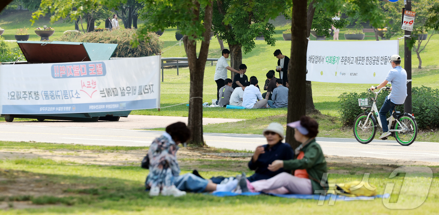 (서울=뉴스1) 김진환 기자 = 낮 기온이 최고 28도까지 오르며 초여름 날씨를 보인 27일 서울 영등포구 여의도 한강공원을 찾은 시민들이 더위를 식히고 있다. 2025.5.27/ …