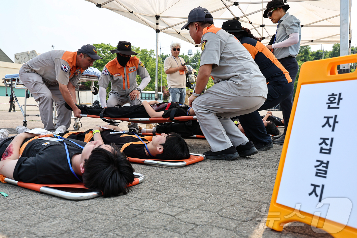 (하남=뉴스1) 김도우 기자 = 소방대원과 의용소방대원들이 27일 경기 하남 미사경정공원에서 열린 경기도소방재난본부 주관 '2025 경기도 긴급구조종합훈련'에서 부상자를 구조하고 …