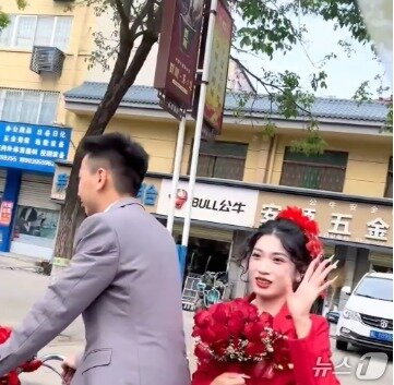 본문 이미지 - 박수를 치는 마을 사람들에게 손을 흔들고 있는 신부. SCMP 갈무리