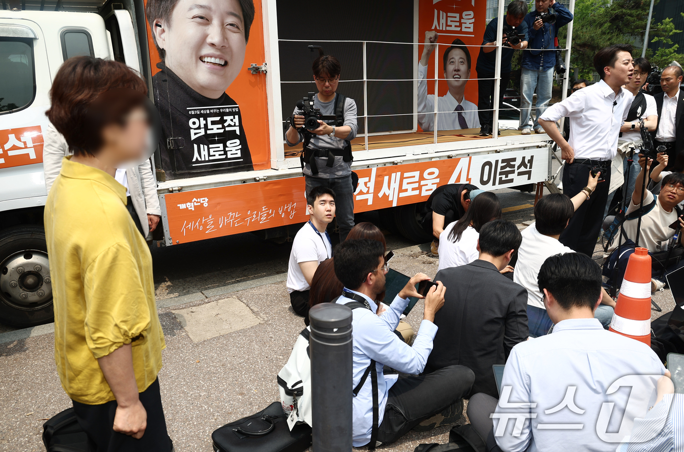 (서울=뉴스1) 김민지 기자 = 이준석 개혁신당 대통령 후보가 28일 서울 영등포구 여의도공원에서 유세를 마치고 취재진 질의에 답변하고 있는 가운데 한 시민이 이 후보가 전날 토론 …