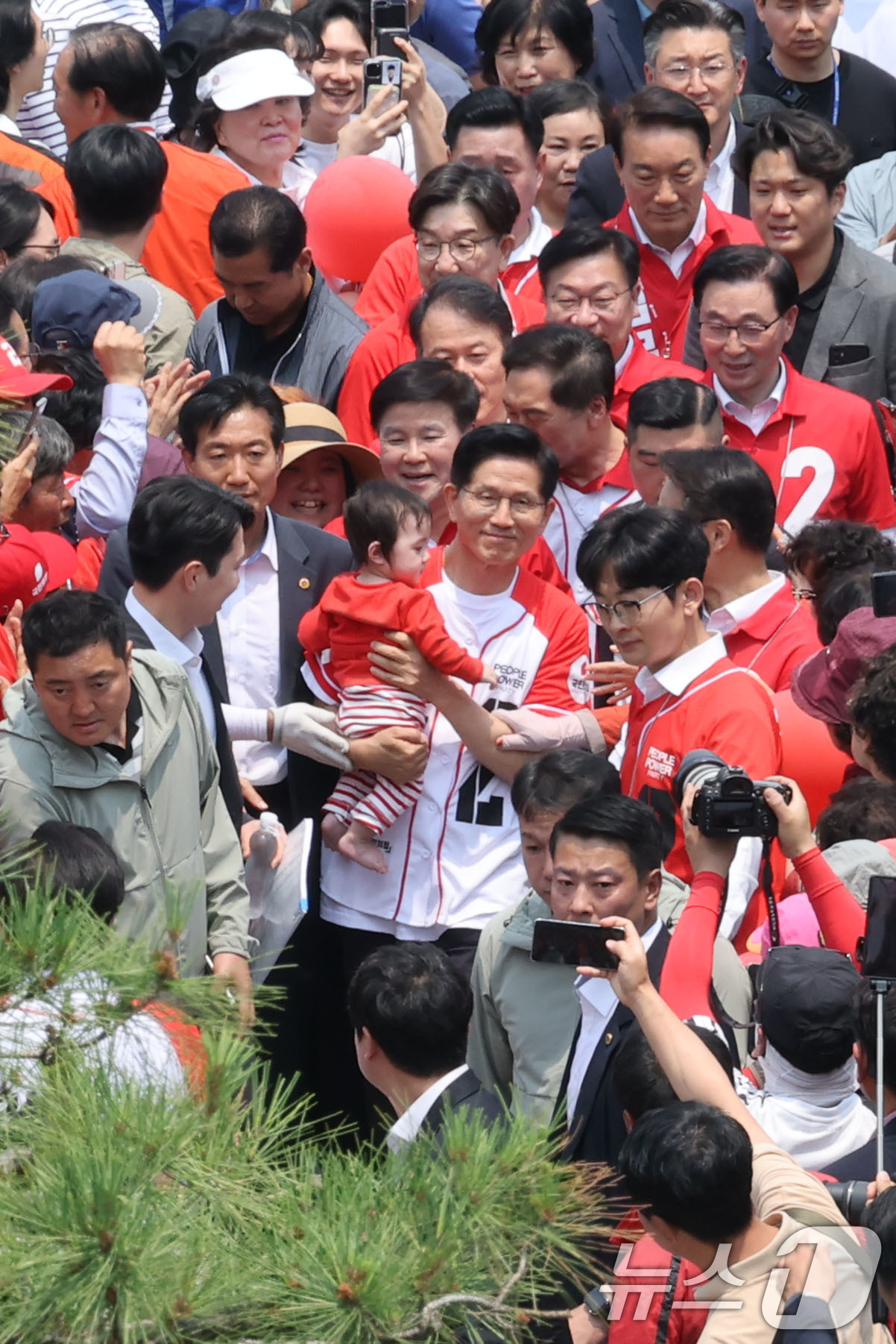 (김해=뉴스1) 이광호 기자 = 김문수 국민의힘 대통령 후보가 28일 경남 김해시 김수로왕릉공원 앞 유세에서 아이를 안고 유세 차량으로 이동하고 있다. 2025.5.28/뉴스1