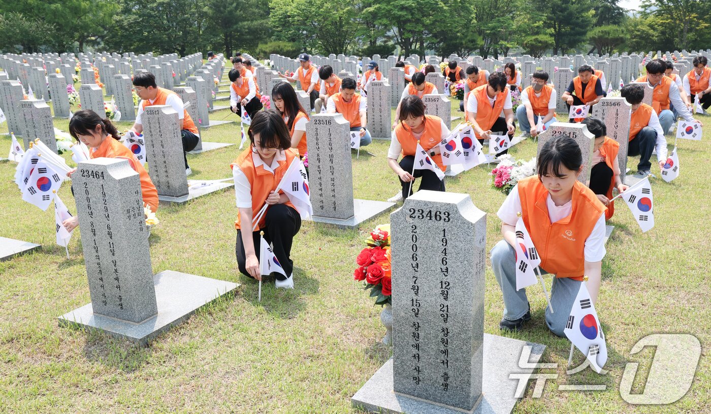 본문 이미지 - 28일 대전 유성구 국립대전현충원 3묘역에서 김신연 한화사회봉사단장(한화솔루션 사장)을 비롯해 한화에어로스페이스, 한화첨단소재, ㈜한화 글로 벌부문, 한화솔루션 중앙연구소, 한화모멘텀, 한화갤러리아, 한화토탈에너 지스, 한화임팩트, 한화손해보험 등 대전·충청지역의 사업장 대표와 임직 원들 70여명이 묘역에 태극기 태극기 꽂기와 묘역 정비 활동을 진행하고 있다. 2025.5.28/뉴스1 ⓒ News1 김기태 기자