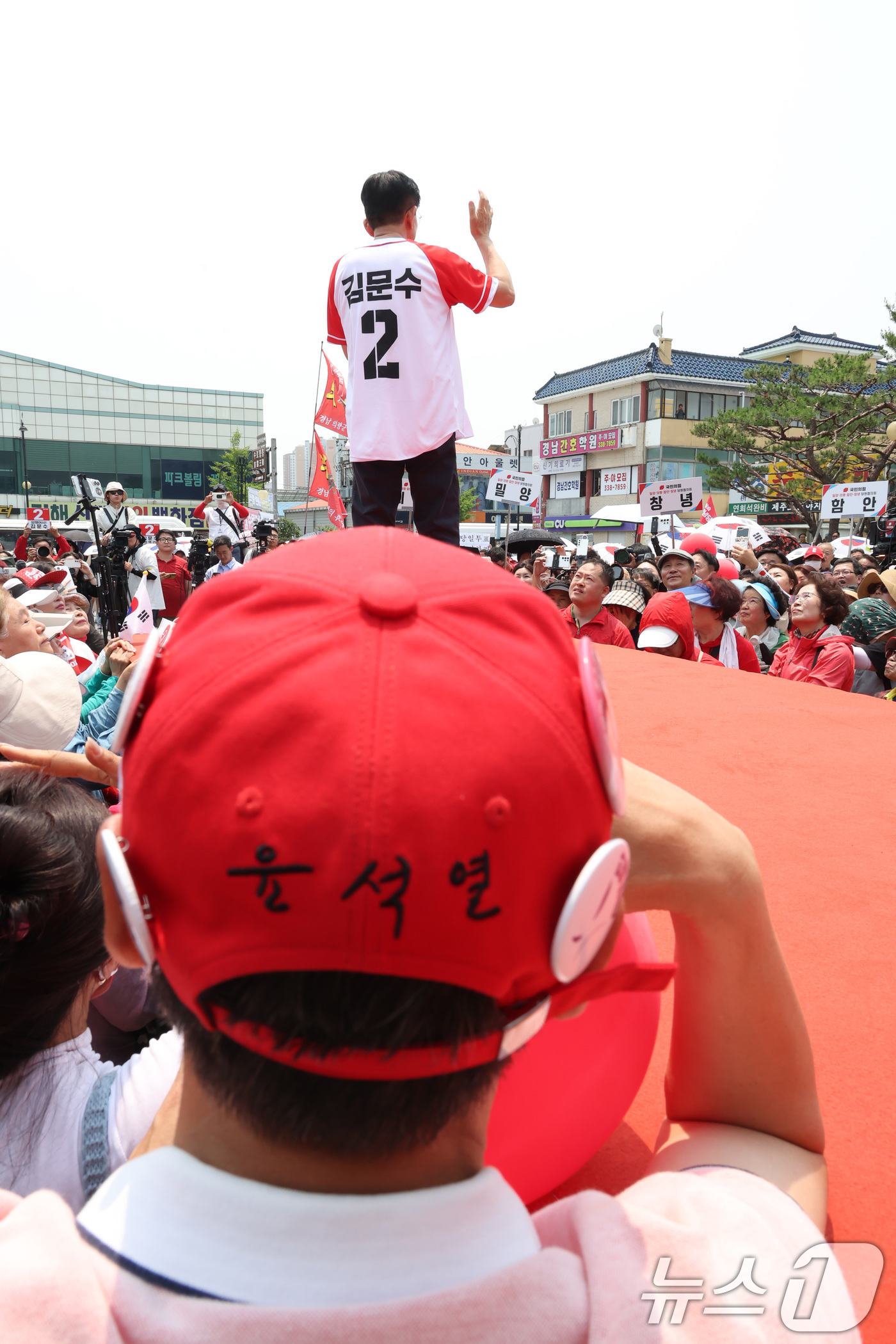 (김해=뉴스1) 이광호 기자 = 김문수 국민의힘 대통령 후보가 28일 경남 김해시 김수로왕릉공원 앞 유세에서 시민들에게 지지를 호소하는 가운데 한 시민이 윤석열 글자가 새겨진 모자 …