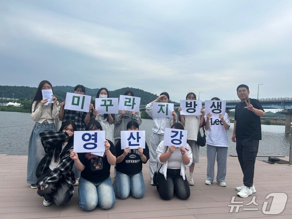 본문 이미지 - 환경동아리 학생들이 영산강에 미꾸라지를 방생한 후 기념사진을 찍고 있다. &#40;전남도교육청 제공, 재판매 및 DB 금지&#41; 