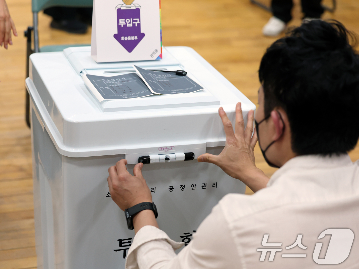 (서울=뉴스1) 황기선 기자 = 제21대 대통령 선거 사전 투표 첫날인 29일 오전 서울 종로구 무악동주민센터에 마련된 사전투표소에서 투표관리관이 투표함을 봉인하고 있다.  202 …