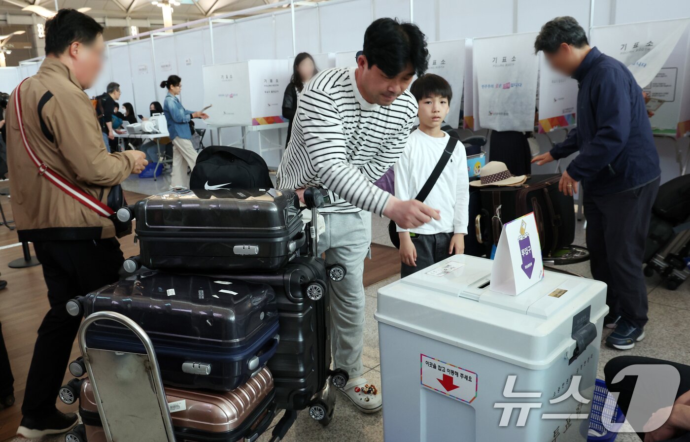 본문 이미지 - 제21대 대통령선거 사전투표일인 29일 오전 인천공항에서 가족이 출국 전 투표를 하고 있다. 2025.5.29/뉴스1 ⓒ News1 김명섭 기자