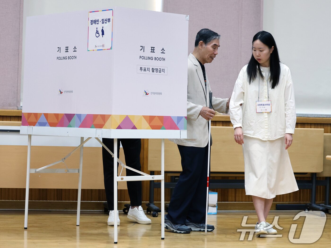 본문 이미지 - 제21대 대통령 선거 사전 투표 첫날인 29일 오전 서울 종로구 무악동주민센터에 마련된 사전투표소에서 시각장애인 유권자가 사전투표사무원의 도움을 받으며 투표를 하고 있다. 2025.5.29/뉴스1 ⓒ News1 황기선 기자