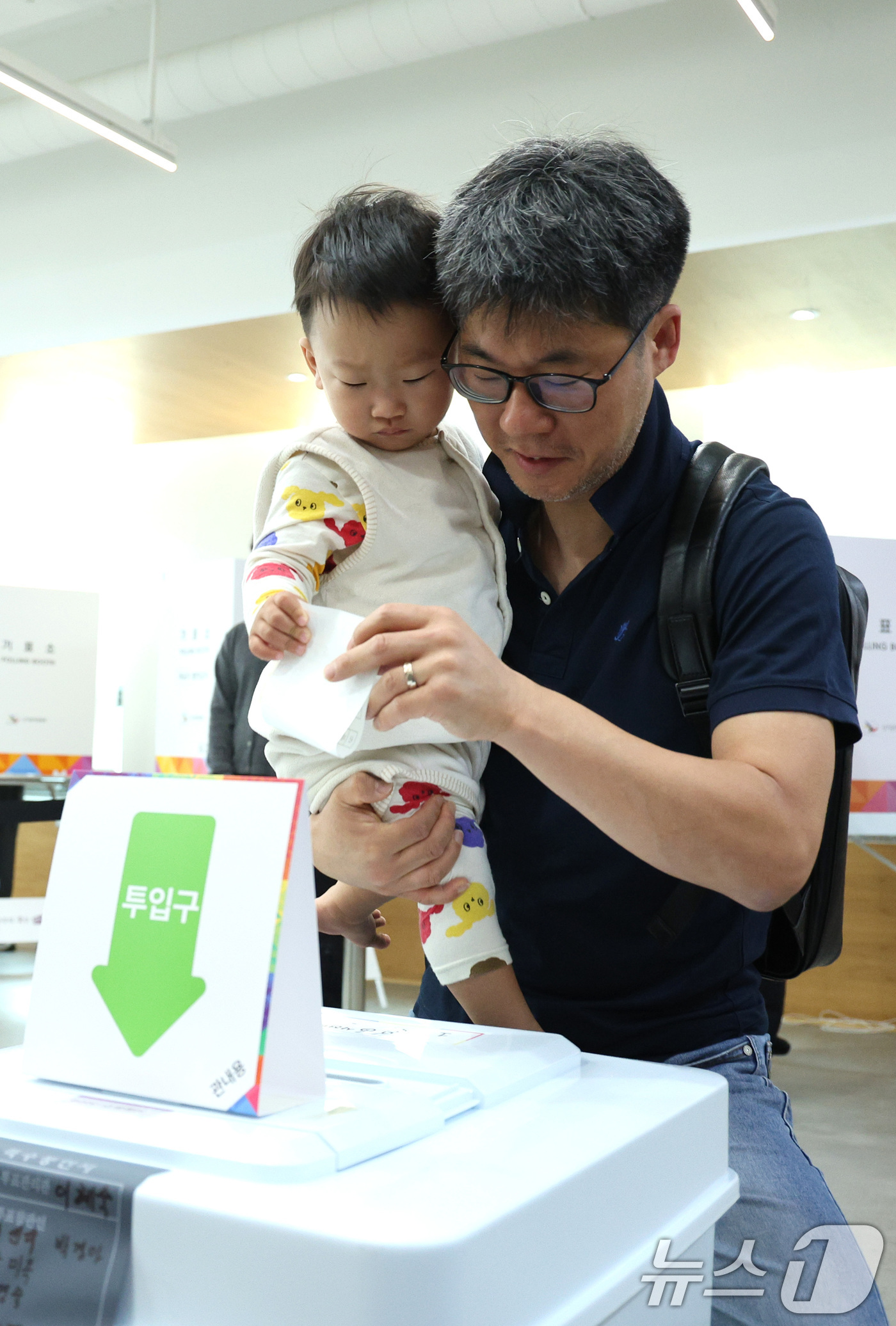 (서울=뉴스1) 신웅수 기자 = 제21대 대통령 선거 사전 투표 첫날인 29일 오전 서울 중구 중림동주민센터에 마련된 사전투표소에서 한 유권자가 아이와 함께 투표하고 있다. 202 …