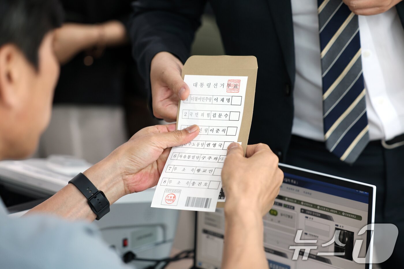 본문 이미지 - 제21대 대통령 사전투표 첫날인 29일 광주 동구 서남동 사전투표소에서 선거사무원이 유권자에게 투표 용지를 건네고 있다. 2025.5.29/뉴스1 ⓒ News1 이승현 기자