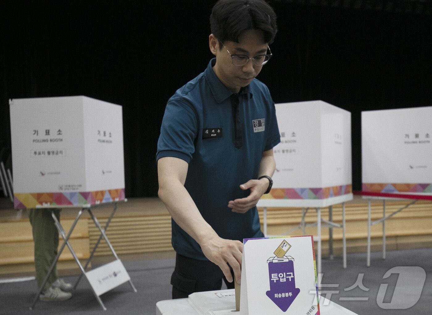 본문 이미지 - 제21대 대통령선거 사전투표 첫날인 29일 오전 울산 남구청 6층에 마련된 사전투표소에 한 경찰관이 투표함에 투표 용지를 넣고 있다.2025.5.29/뉴스1 ⓒ News1 김지혜 기자