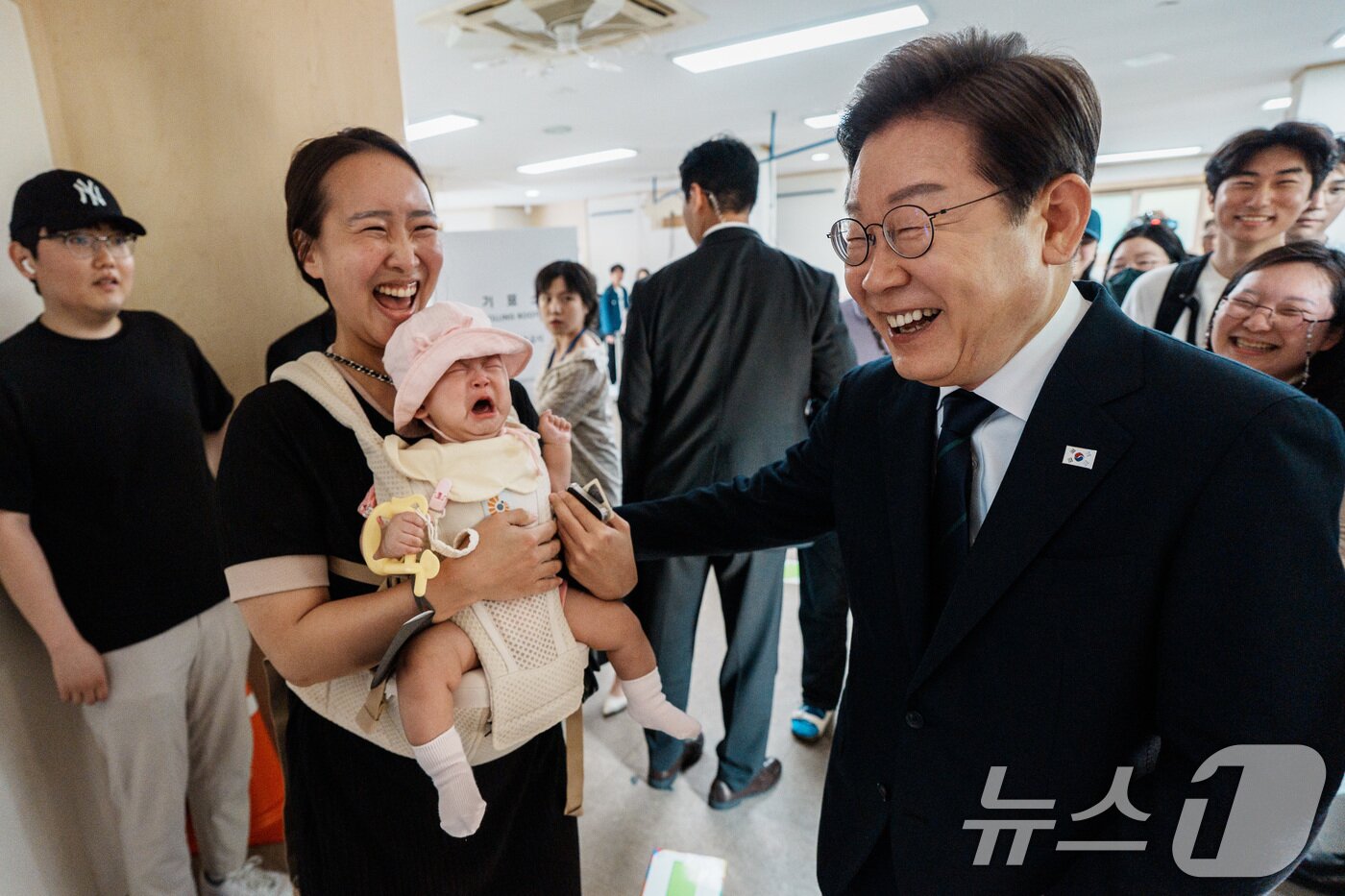 본문 이미지 - 이재명 더불어민주당 대통령 후보가 제21대 대통령선거 사전투표 첫날인 29일 오전 서울 서대문구 구 신촌동주민센터에서 청년들과 사전투표를 마친 뒤 아이를 안은 주민과 인사하고 있다. (공동취재) 2025.5.29/뉴스1 ⓒ News1 안은나 기자