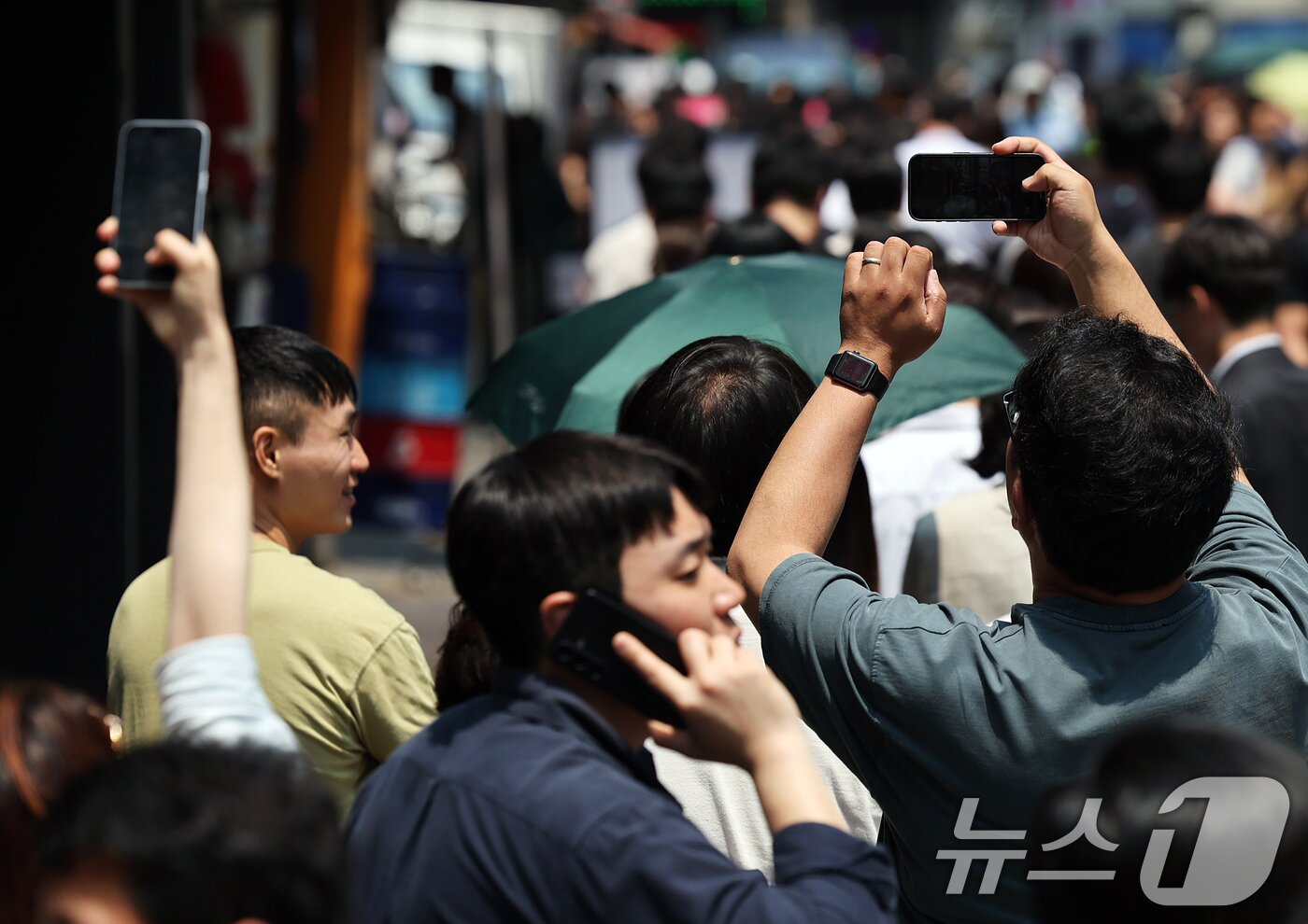 본문 이미지 - 제21대 대통령선거 사전투표 첫 날인 29일 서울 중구 소공동주민센터에 마련된 투표소에서 직장인들이 점심시간 투표를 위해 대기하며 길게 늘어선 투표 인파를 스마트폰에 담고 있다. 2025.5.29/뉴스1 ⓒ News1 오대일 기자
