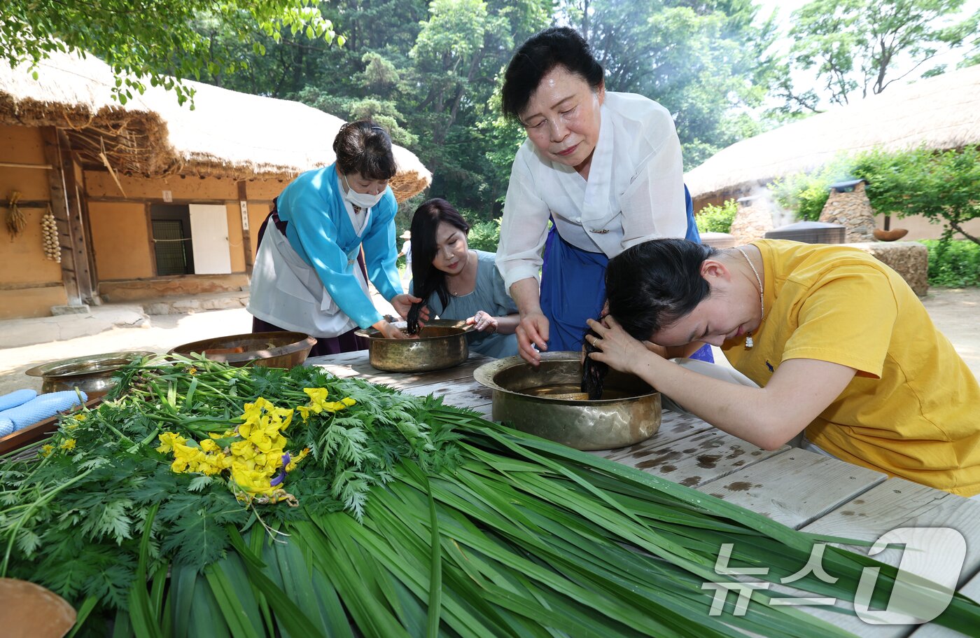 본문 이미지 - 단오&#40;음력 5월5일&#41;를 이틀 앞둔 29일 경기 용인시 기흥구 한국민속촌에서 관광객들이 창포물에 머리 감기 체험을 하고 있다. 2025.5.29/뉴스1 ⓒ News1 김영운 기자