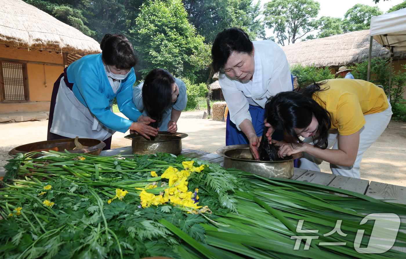 (용인=뉴스1) 김영운 기자 = 단오(음력 5월5일)를 이틀 앞둔 29일 경기 용인시 기흥구 한국민속촌에서 관광객들이 창포물에 머리 감기 체험을 하고 있다. 2025.5.29/뉴스 …