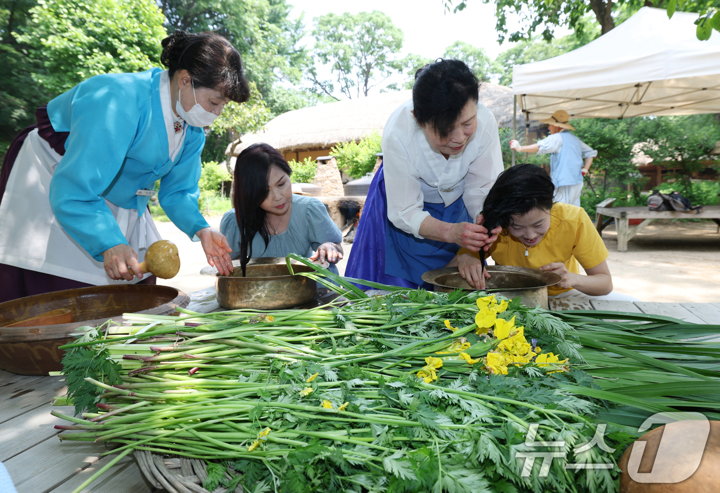 (용인=뉴스1) 김영운 기자 = 단오(음력 5월5일)를 이틀 앞둔 29일 경기 용인시 기흥구 한국민속촌에서 관광객들이 창포물에 머리 감기 체험을 하고 있다. 2025.5.29/뉴스 …