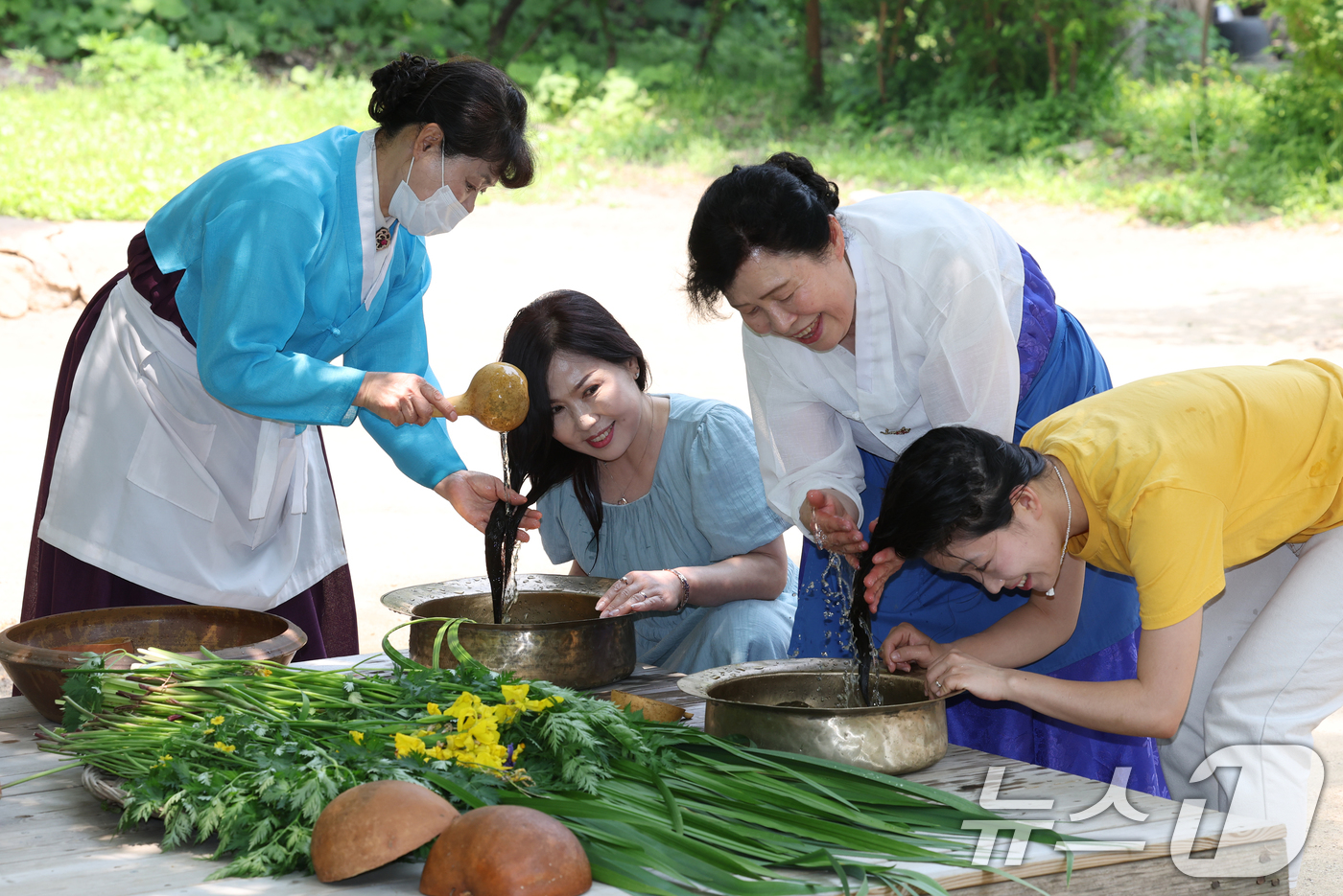 (용인=뉴스1) 김영운 기자 = 단오(음력 5월5일)를 이틀 앞둔 29일 경기 용인시 기흥구 한국민속촌에서 관광객들이 창포물에 머리 감기 체험을 하고 있다. 2025.5.29/뉴스 …