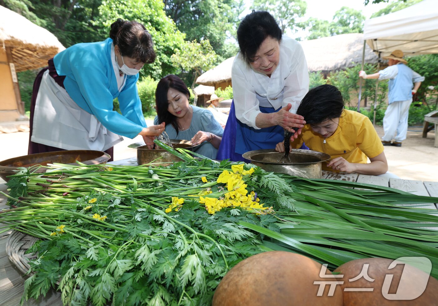 본문 이미지 - 단오&#40;음력 5월5일&#41;를 이틀 앞둔 29일 경기 용인시 기흥구 한국민속촌에서 관광객들이 창포물에 머리 감기 체험을 하고 있다. 2025.5.29/뉴스1 ⓒ News1 김영운 기자