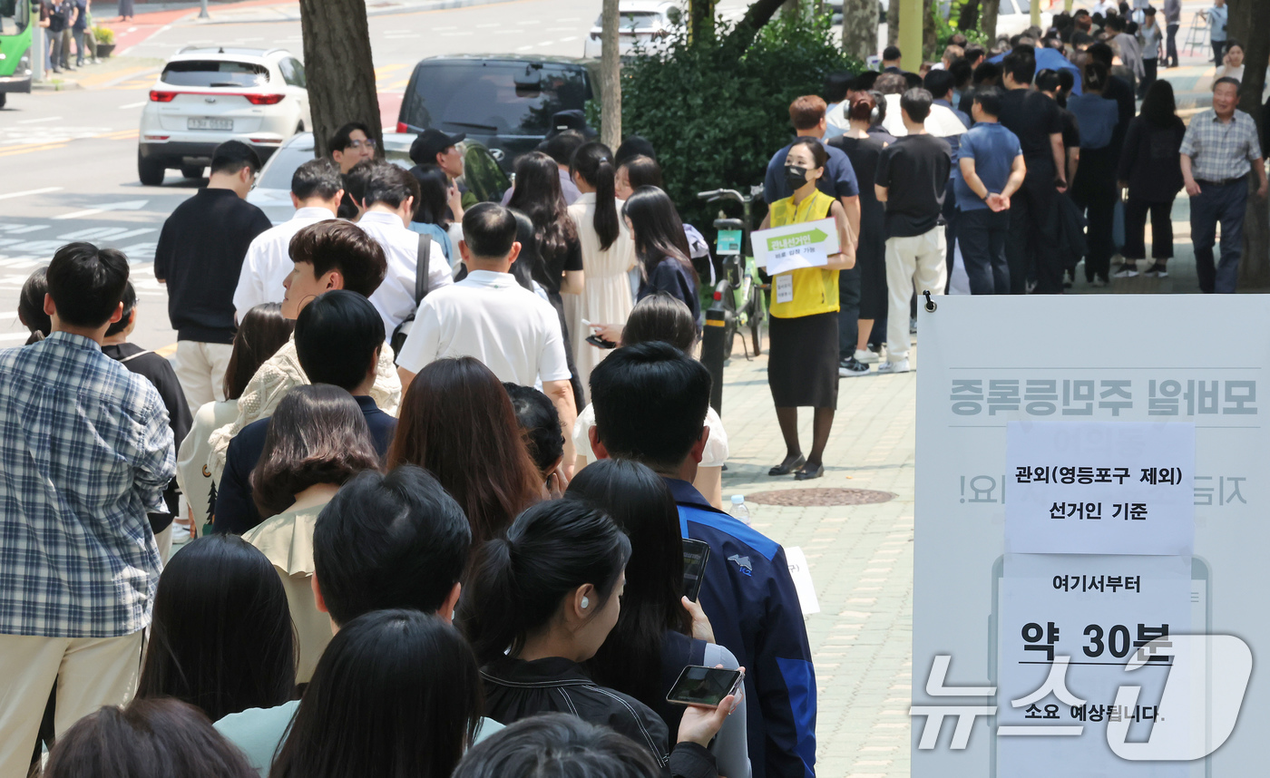 (서울=뉴스1) 장수영 기자 = 제21대 대통령 선거 사전 투표 첫날인 29일 서울 영등포구 여의동주민센터에 마련된 사전투표소를 찾은 유권자들이 점심시간 중 투표를 하기 위해 긴 …