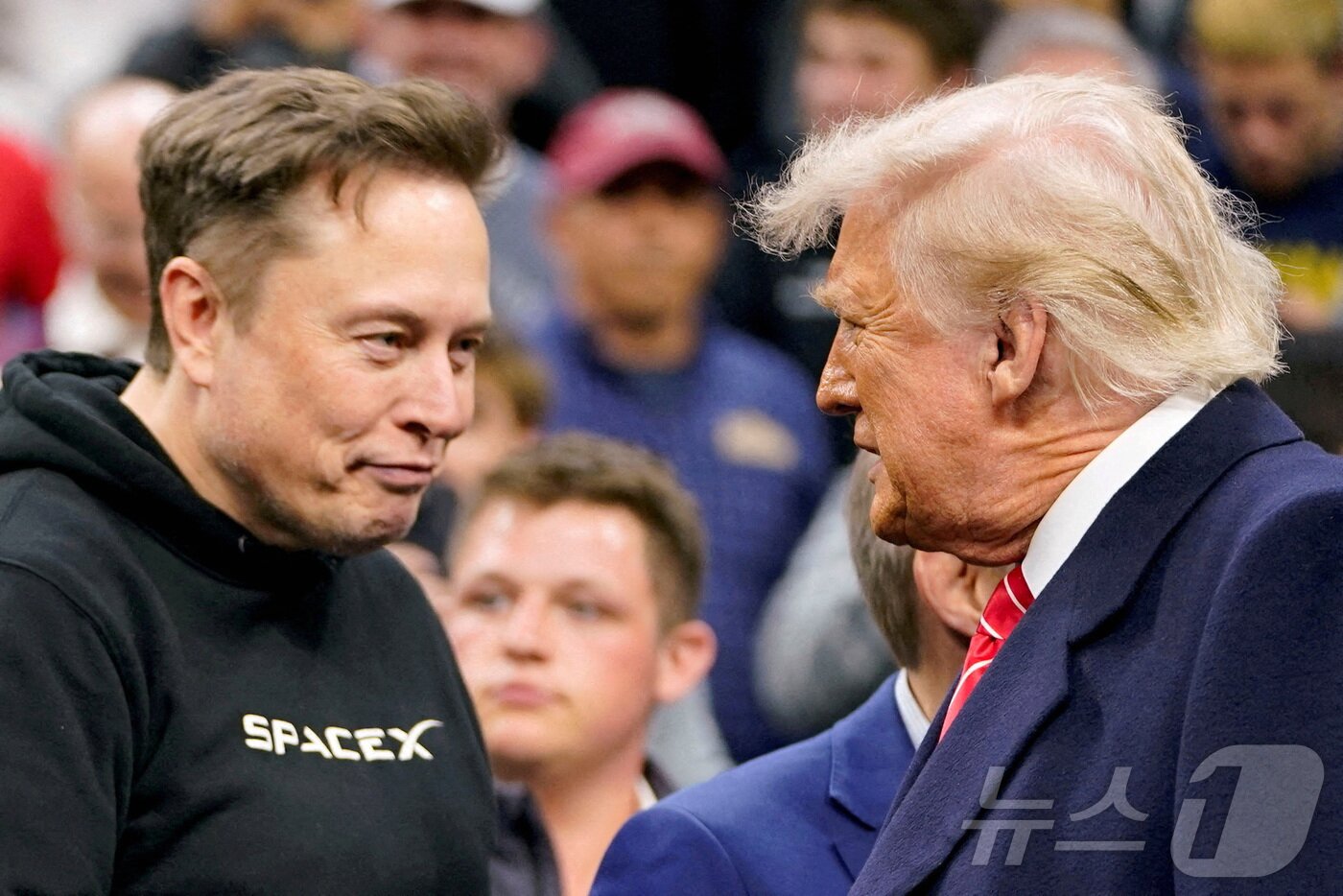 본문 이미지 - 일론 머스크 테슬라 최고경영자&#40;CEO&#41;가 2025년 3월 22일 미국 펜실베이니아주 필라델피아에서 열린 NCAA 남자 레슬링 챔피언십에 참석한 도널드 트럼프 미국 대통령을 맞이하고 있다. 머스크 CEO는 5월28일 소셜미디어에 자신이 &#34;오늘밤부터 업무 정리를 시작할 것＂이라면서 트럼프 행정부를 떠날 것을 밝혔다. 2025.03.22. ⓒ 로이터=뉴스1 ⓒ News1 권영미 기자