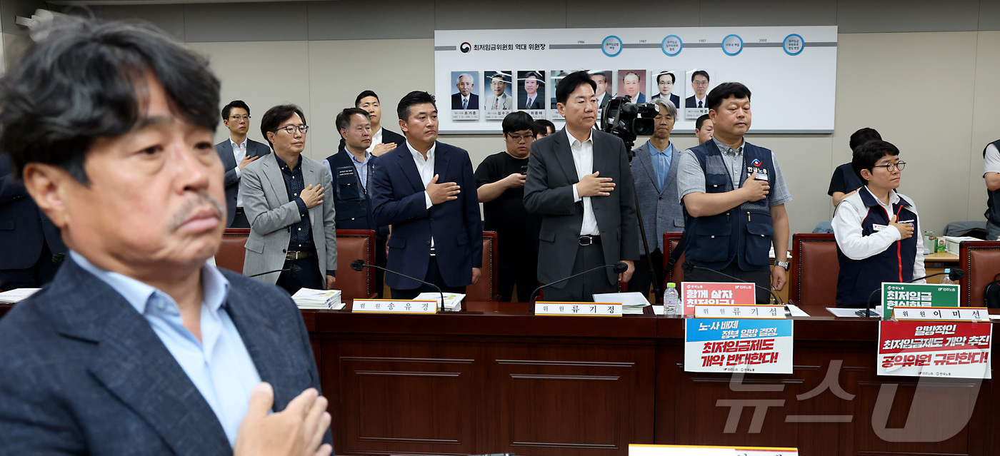 (세종=뉴스1) 김기남 기자 = 29일 오후 세종시 정부세종청사에서 열린 최저임금위원회 제3차 전원회의에 참석한 권순원 공익위원 간사를 비롯한 사용자, 근로자 위원들이 국민의례를 …