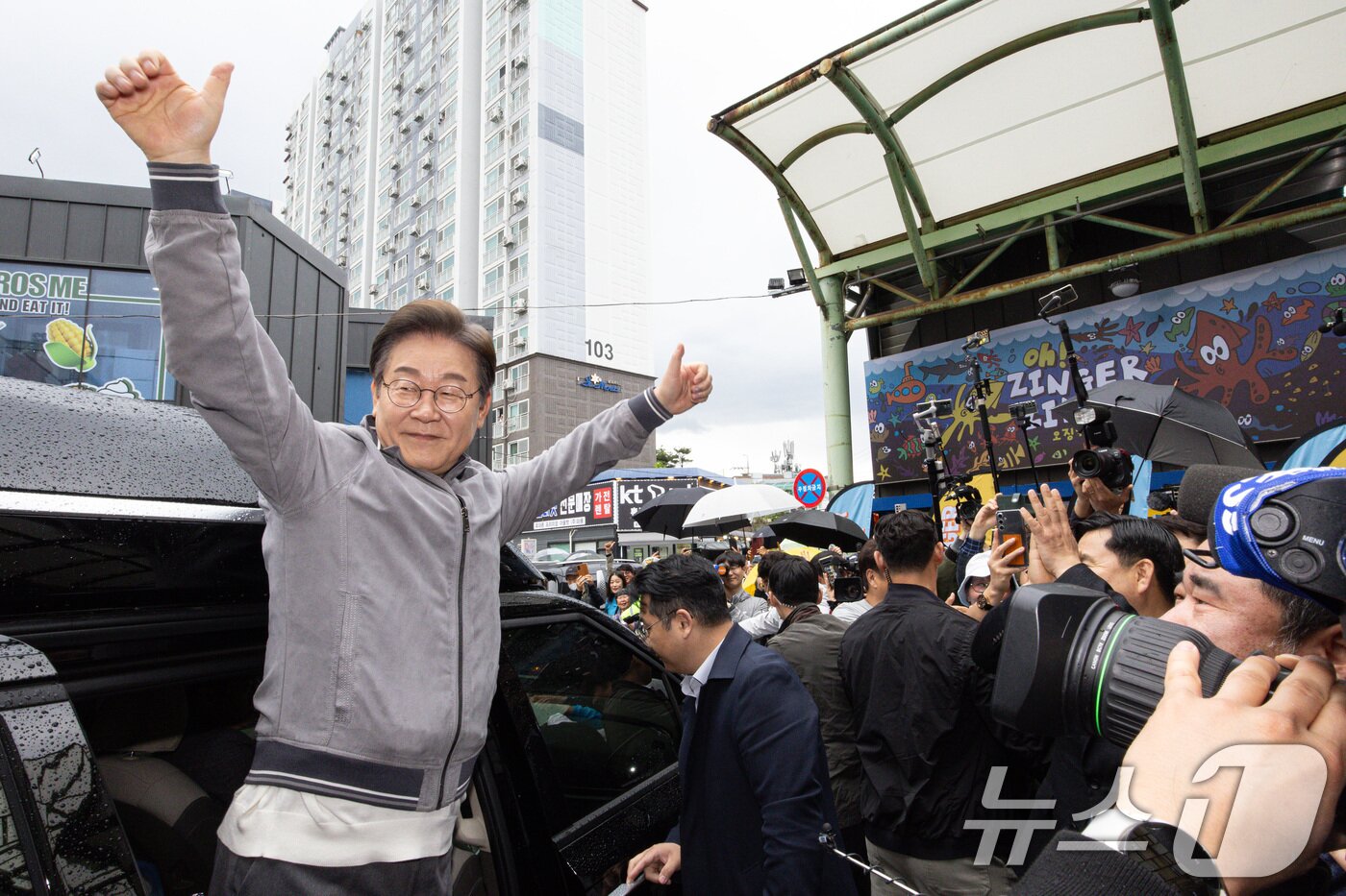 본문 이미지 - &#39;골목골목 경청투어 : 동해안벨트편&#39;에 나선 이재명 더불어민주당 대통령 후보가 3일 오전 강원 속초시 중앙로 속초관광수산시장에서 시민들과 인사를 나눈 후 차량에 탑승해 인사하고 있다. 2025.5.3/뉴스1 ⓒ News1 이재명 기자