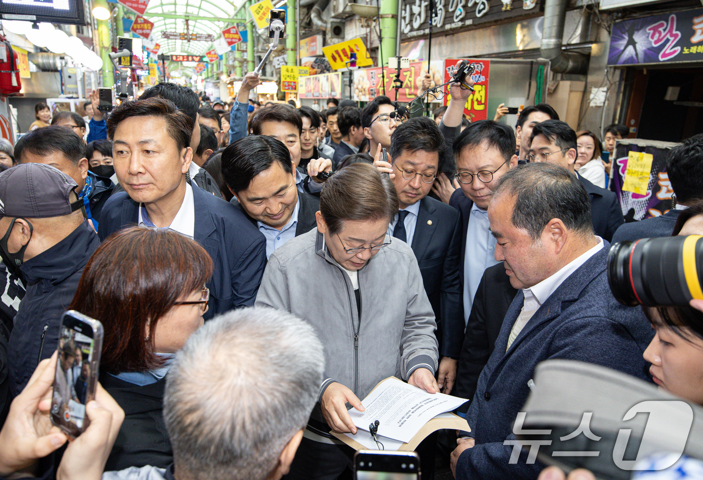 (속초=뉴스1) 이재명 기자 = '골목골목 경청투어 : 동해안벨트편'에 나선 이재명 더불어민주당 대통령 후보가 3일 오전 강원 속초시 중앙로 속초관광수산시장에서 한 시민이 건넨 문 …