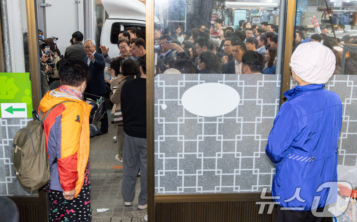 (양양=뉴스1) 이재명 기자 = '골목골목 경청투어 : 동해안벨트편'에 나선 이재명 더불어민주당 대통령 후보가 3일 오전 강원 양양군 양양시장에서 미용실을 찾은 시민들을 향해 손인 …