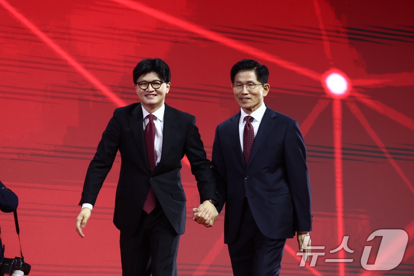 (고양=뉴스1) 김민지 기자 = 한동훈(왼쪽), 김문수 국민의힘 대선 경선 후보가 3일 경기 고양시 킨텍스에서 열린 5차 전당대회에서 대의원들을 향해 인사한 뒤 손을 잡고 있다. …
