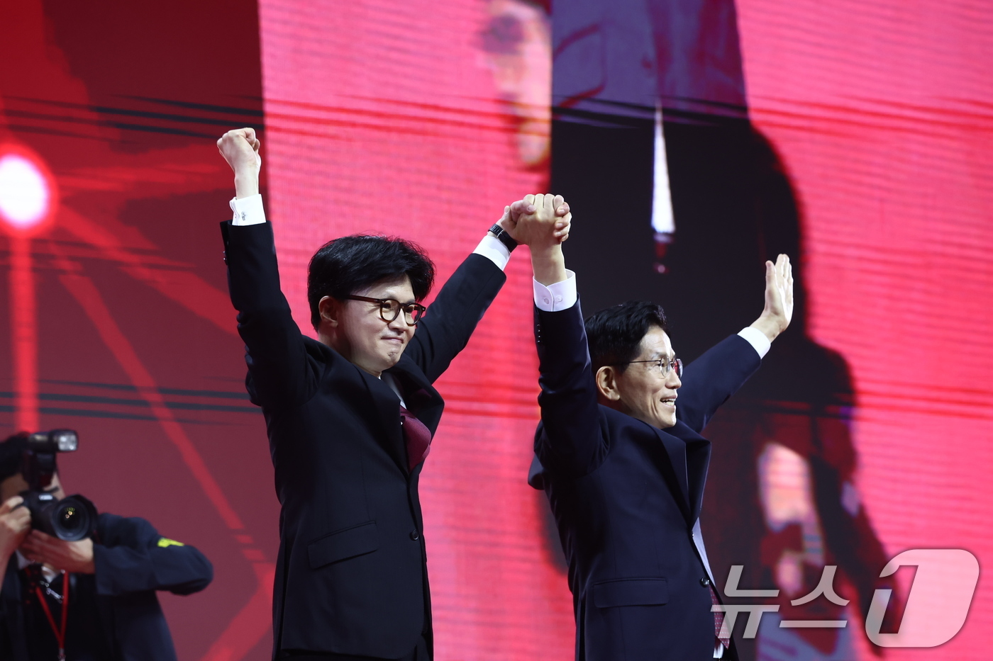 (고양=뉴스1) 김민지 기자 = 한동훈(왼쪽), 김문수 국민의힘 대선 경선 후보가 3일 경기 고양시 킨텍스에서 열린 5차 전당대회에서 손을 맞잡아 들며 인사하고 있다. 2025.5 …