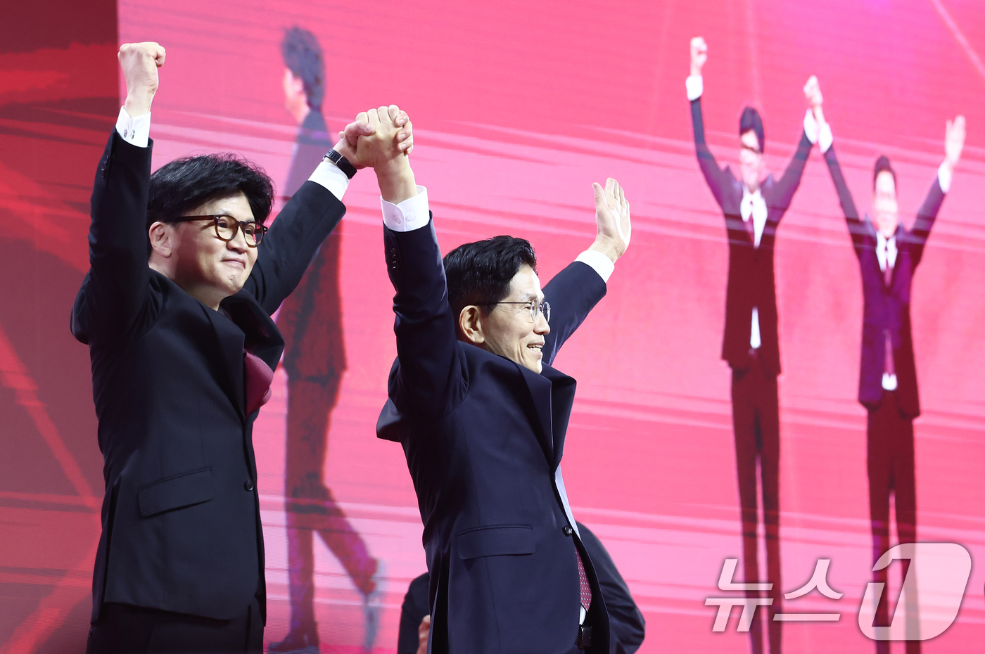 (고양=뉴스1) 김민지 기자 = 국민의힘 김문수, 한동훈 대선 경선 후보가 3일 경기 고양시 킨텍스에서 열린 5차 전당대회에서 손을 맞잡고 기념촬영을 하고 있다. 2025.5.3/ …