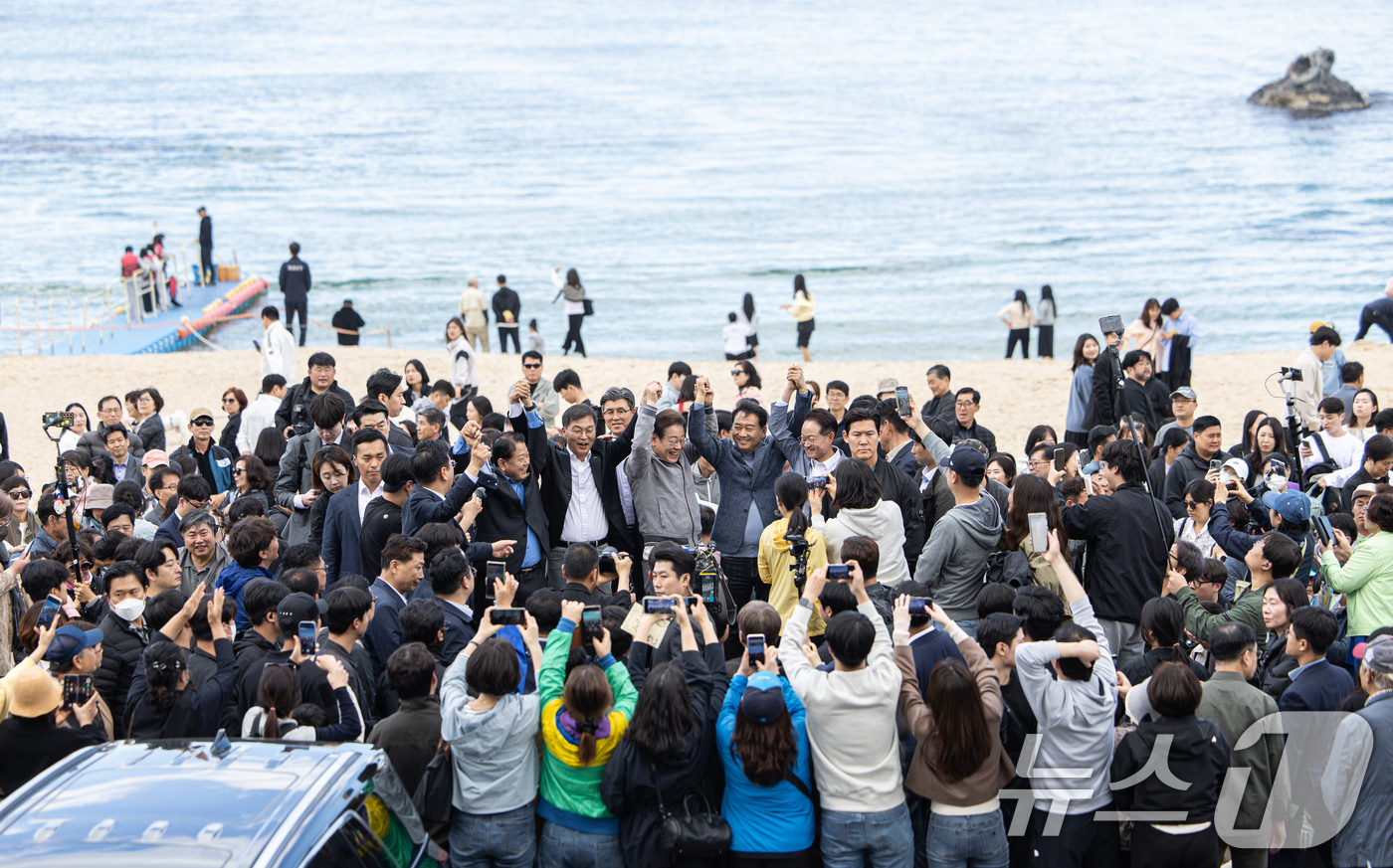 (강릉=뉴스1) 이재명 기자 = '골목골목 경청투어 : 동해안벨트편'에 나선 이재명 더불어민주당 대통령 후보가 3일 오후 강원 강릉시 안목해변에서 시민들을 향해 손을 들어보이고 있 …