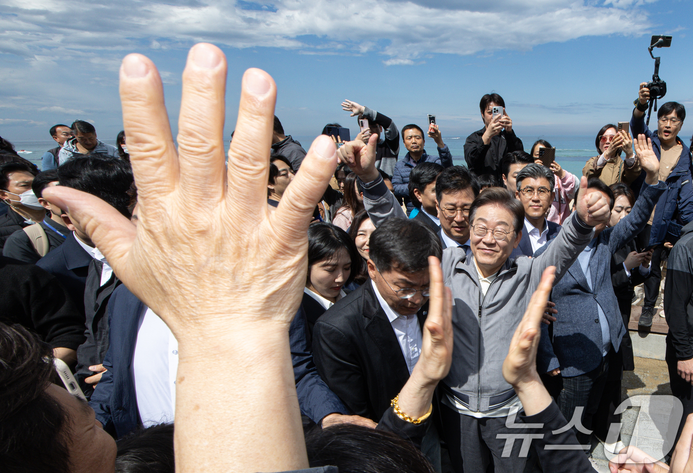 (강릉=뉴스1) 이재명 기자 = '골목골목 경청투어 : 동해안벨트편'에 나선 이재명 더불어민주당 대통령 후보가 3일 오후 강원 강릉시 안목해변에서 지지자들과 인사를 하고 있다. 2 …